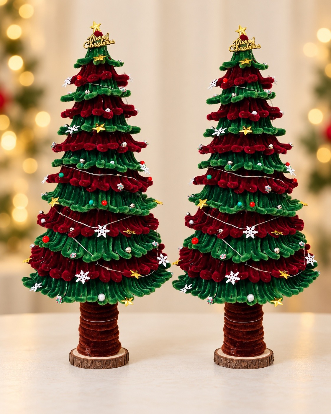 Two red and green handcrafted Christmas trees with gold stars and snowflake decorations
