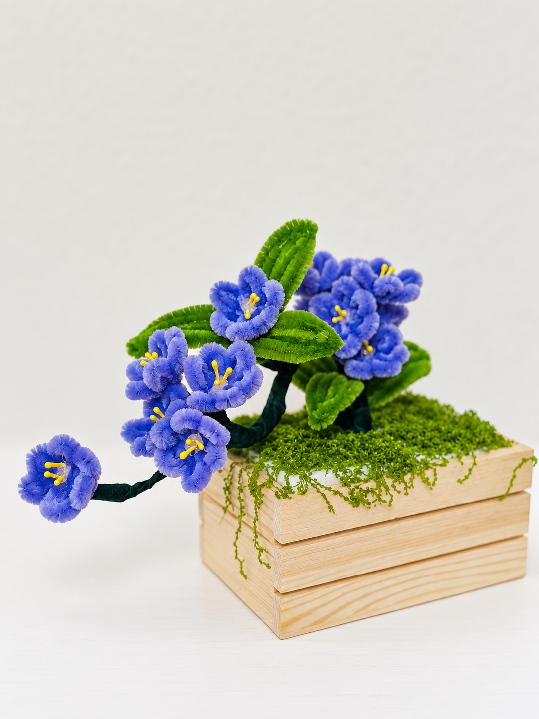 Blue blooms in a wooden planter — handcrafted flower arrangement