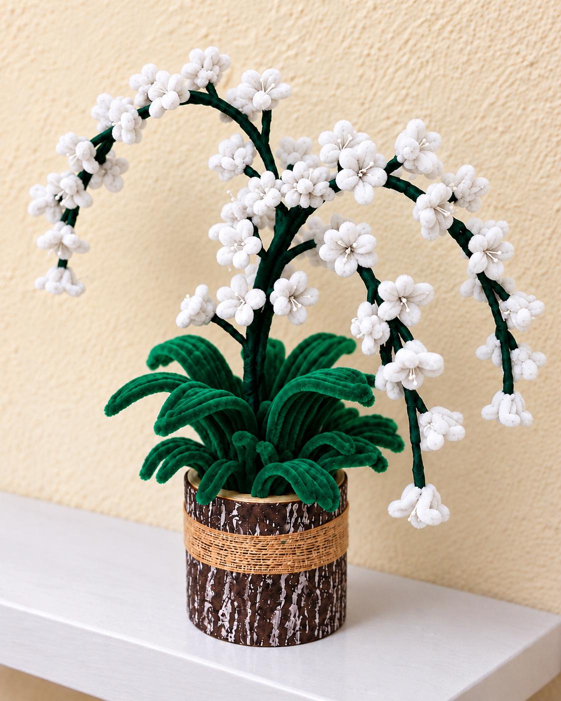 White handcrafted blossom arrangement with arching branches and green leaves in a rustic brown pot